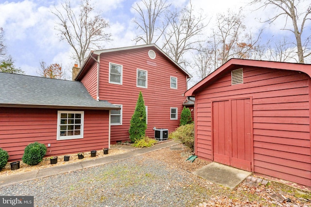 back of property featuring a storage unit and central air condition unit