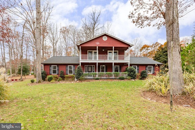 view of front of property featuring a balcony and a front lawn