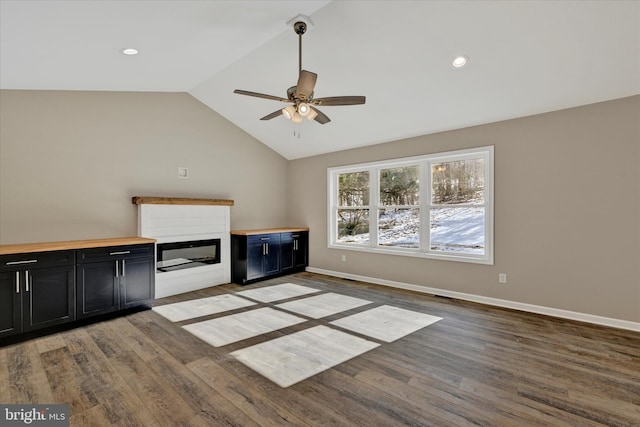 unfurnished living room with vaulted ceiling, wood-type flooring, and ceiling fan