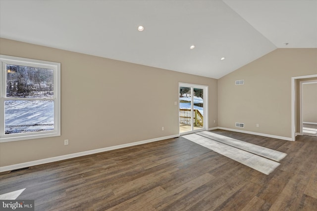 spare room featuring lofted ceiling and dark hardwood / wood-style floors