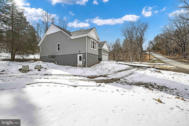 view of snowy exterior featuring a garage