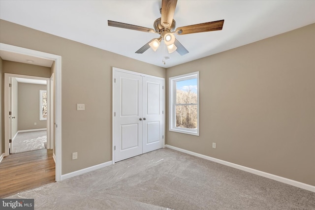 unfurnished bedroom featuring light carpet, ceiling fan, and a closet