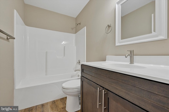 full bathroom with hardwood / wood-style flooring, vanity, toilet, and shower / bathing tub combination