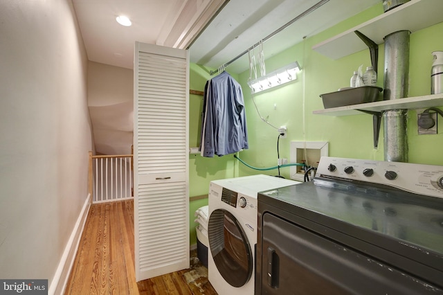 washroom with hardwood / wood-style flooring and independent washer and dryer