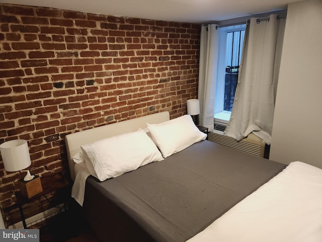 bedroom featuring brick wall and multiple windows