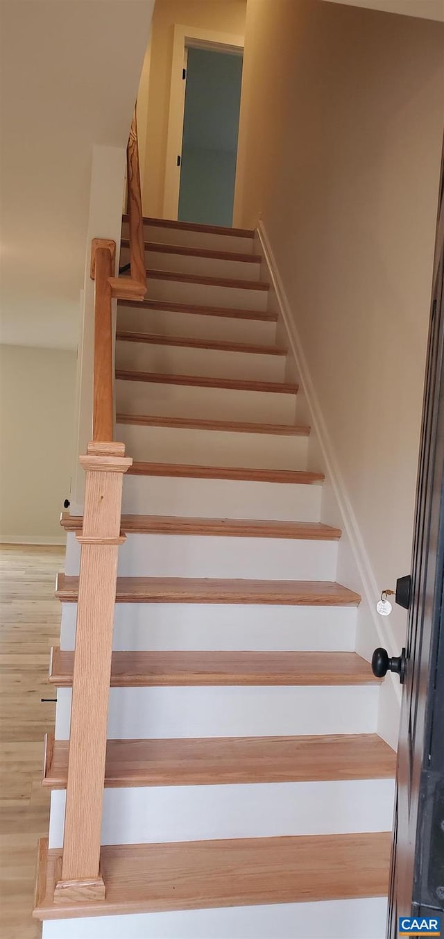 staircase with hardwood / wood-style floors