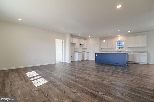 unfurnished living room featuring dark hardwood / wood-style floors and sink