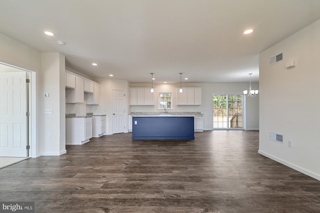 kitchen with pendant lighting, a center island, sink, dark hardwood / wood-style floors, and white cabinetry