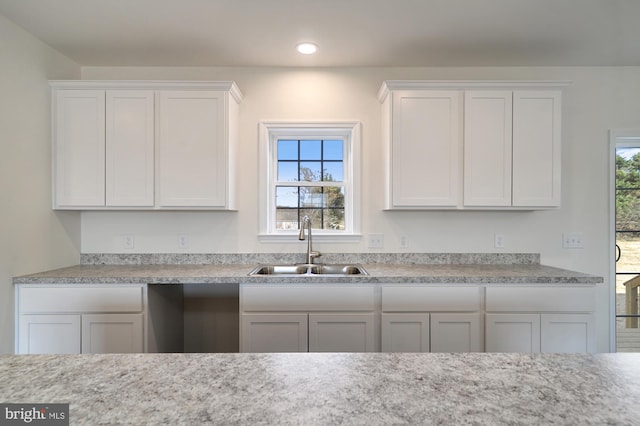 kitchen with white cabinetry, sink, and a healthy amount of sunlight