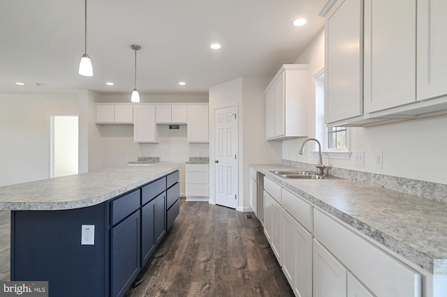 kitchen with a kitchen island, white cabinetry, decorative light fixtures, sink, and dark wood-type flooring