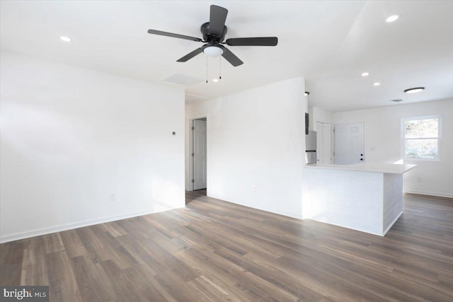 unfurnished living room with ceiling fan and dark hardwood / wood-style flooring