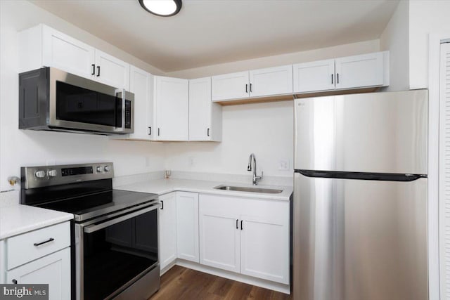 kitchen featuring stainless steel appliances, white cabinetry, and sink