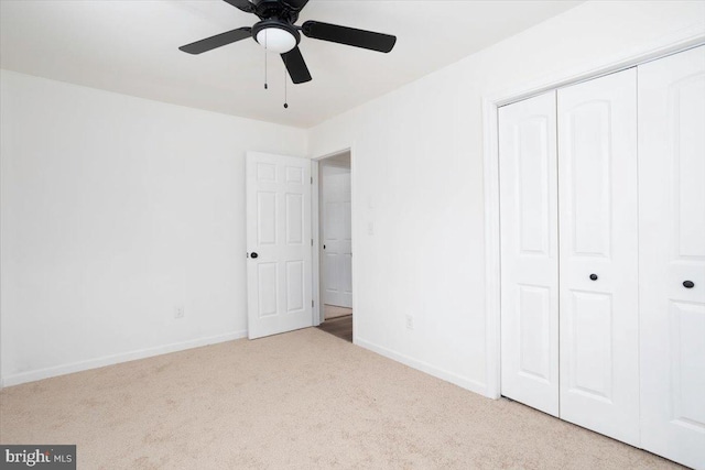 unfurnished bedroom with a closet, ceiling fan, and light colored carpet