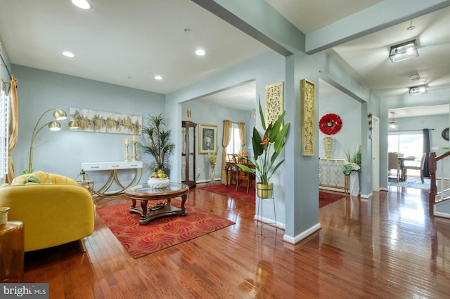 sitting room featuring beamed ceiling and hardwood / wood-style floors