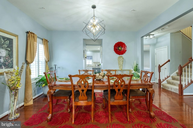 dining area featuring dark hardwood / wood-style flooring and an inviting chandelier