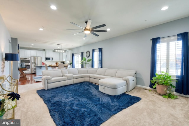 carpeted living room featuring ceiling fan