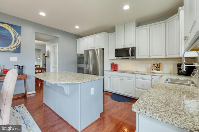 kitchen featuring a kitchen island, dark hardwood / wood-style flooring, white cabinetry, and appliances with stainless steel finishes