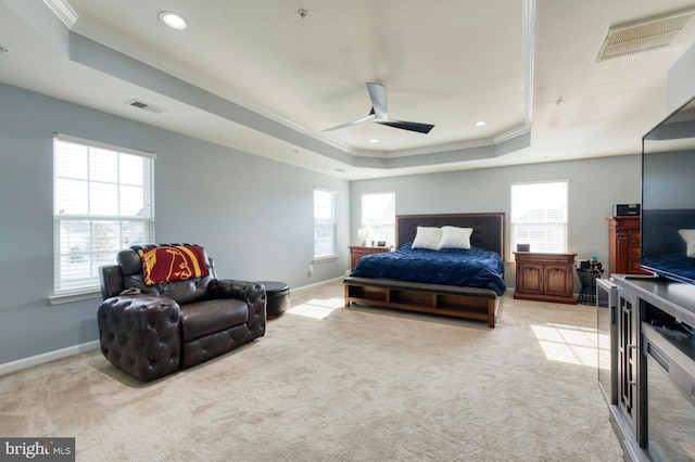 carpeted bedroom featuring a raised ceiling, multiple windows, ceiling fan, and ornamental molding