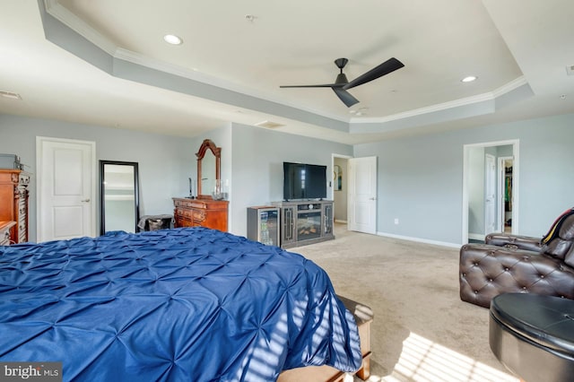 carpeted bedroom with ceiling fan, a fireplace, crown molding, and a tray ceiling