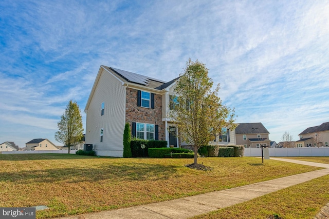 view of front facade featuring a front lawn and solar panels