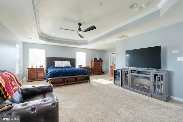 bedroom featuring light colored carpet, a raised ceiling, ceiling fan, and crown molding