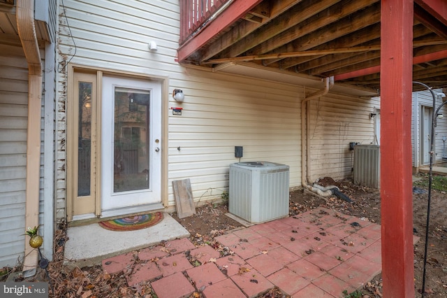 doorway to property with central air condition unit and a patio