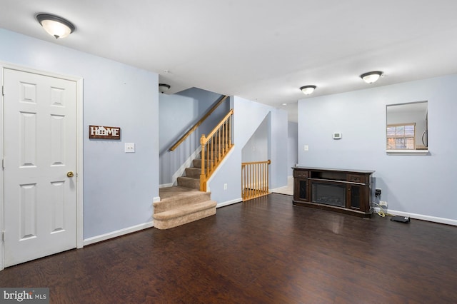 unfurnished living room featuring a fireplace and dark wood-type flooring