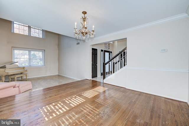 interior space featuring light hardwood / wood-style floors, ornamental molding, and a chandelier