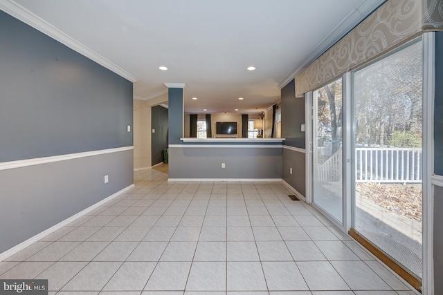 interior space featuring kitchen peninsula, crown molding, and light tile patterned floors