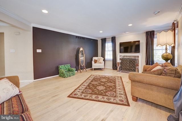 living room featuring crown molding, a fireplace, and hardwood / wood-style flooring