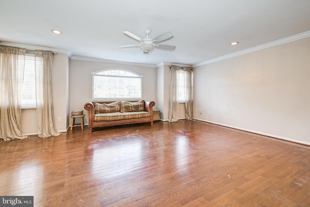 sitting room with hardwood / wood-style flooring, ceiling fan, and crown molding