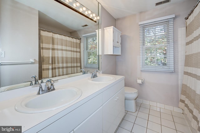 bathroom with toilet, vanity, tile patterned floors, and plenty of natural light