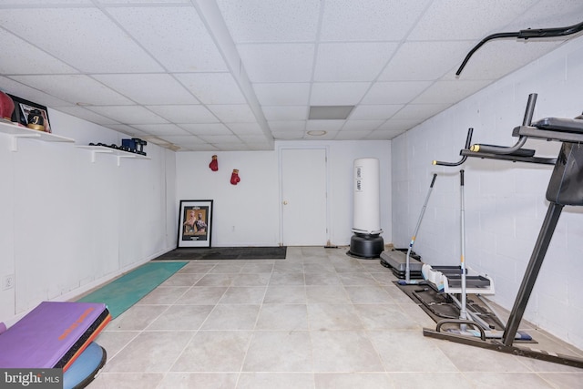 workout room featuring a drop ceiling and light tile patterned flooring