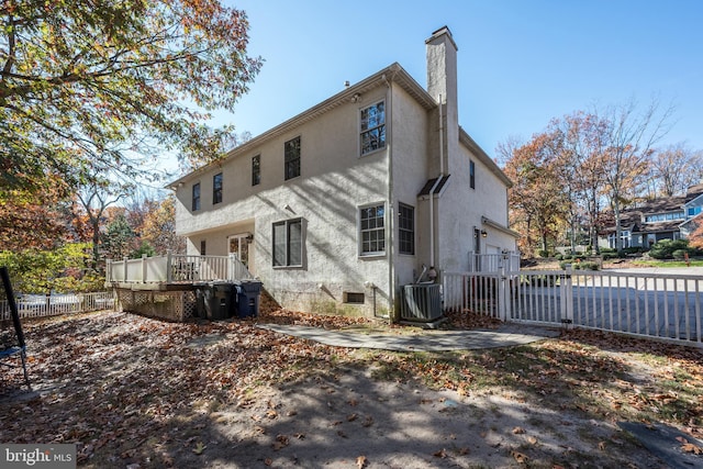 back of property featuring central AC unit and a wooden deck