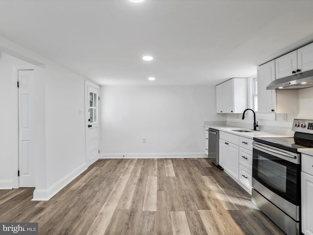 kitchen with white cabinets, light hardwood / wood-style floors, sink, and appliances with stainless steel finishes