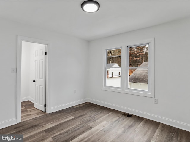 spare room featuring wood-type flooring