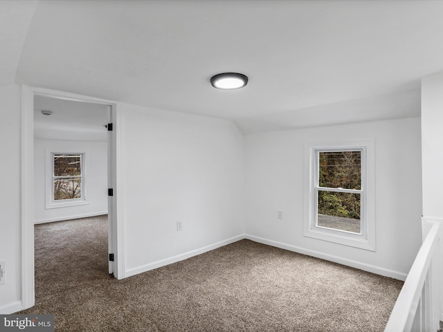 empty room with carpet flooring and vaulted ceiling