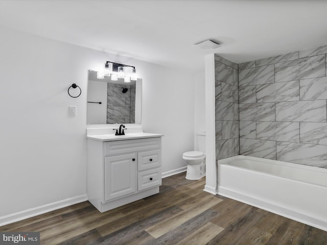 full bathroom featuring vanity, toilet, wood-type flooring, and tiled shower / bath