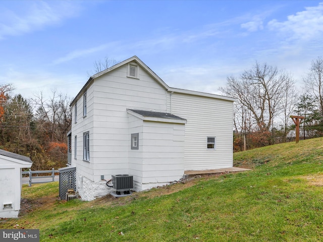 view of home's exterior with central air condition unit and a yard