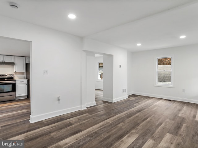 unfurnished living room with dark wood-type flooring