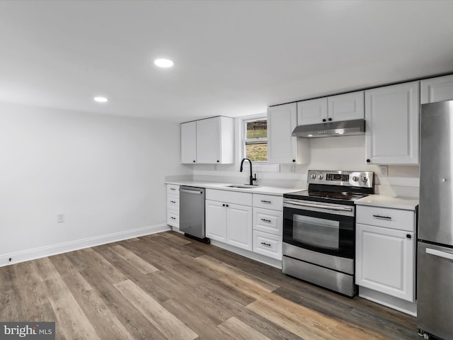 kitchen featuring white cabinets, sink, wood-type flooring, and stainless steel appliances