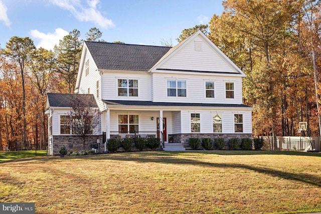 traditional-style home with stone siding, covered porch, and a shingled roof
