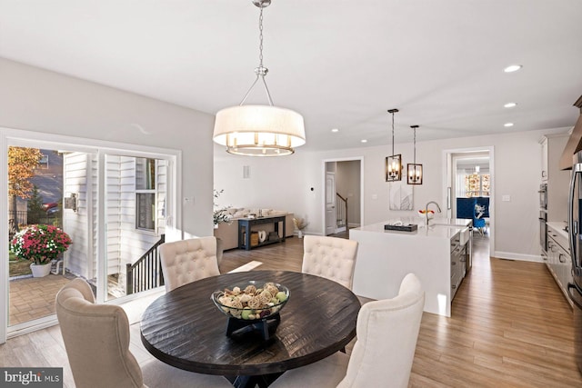 dining space with recessed lighting, light wood-type flooring, baseboards, a chandelier, and stairway