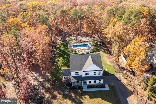 view of subject property with a forest and a pool area