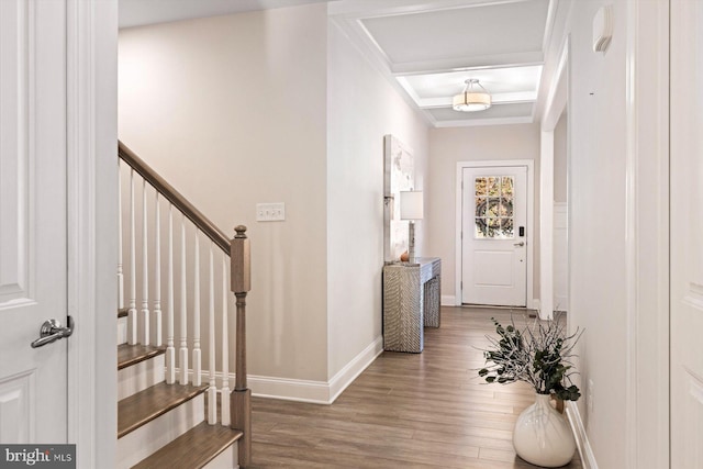 entrance foyer featuring wood finished floors, baseboards, crown molding, and stairs