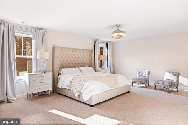 bedroom with carpet floors and a notable chandelier