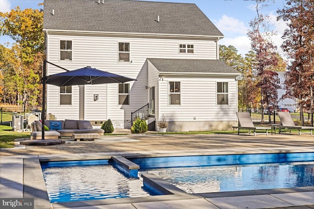 rear view of property featuring a patio area, entry steps, fence, roof with shingles, and an outdoor living space