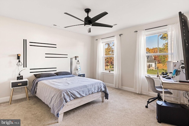 carpeted bedroom featuring ceiling fan and multiple windows