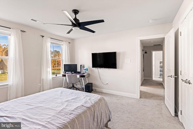 carpeted bedroom featuring multiple windows and ceiling fan