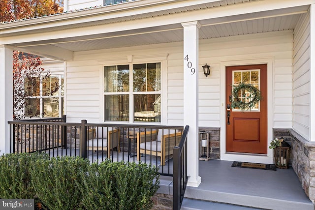 property entrance featuring a porch and stone siding